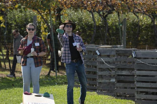 Two alumni play cornhole at the Alumni & Family Apple Picking Outing