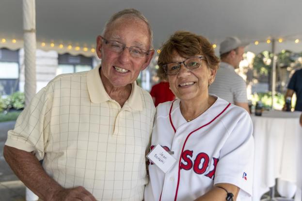 Two older alumni smile on the quad at the Red Sox event