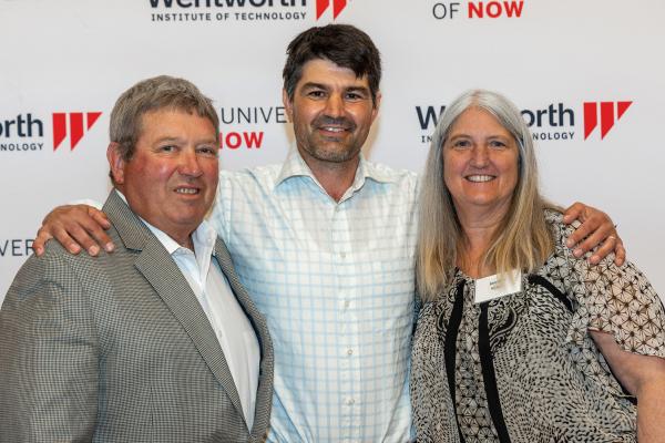 Wentworth Alumni pose in front of the step and repeat