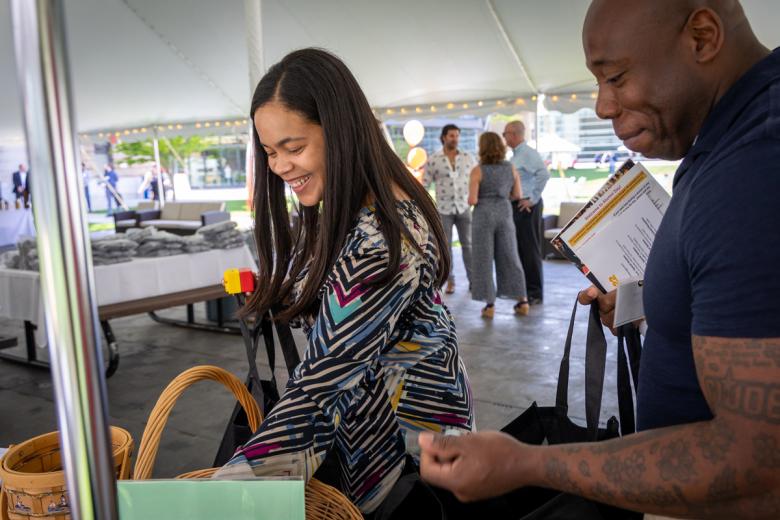 Two Wentworth Alumni smile under the tent on the quad
