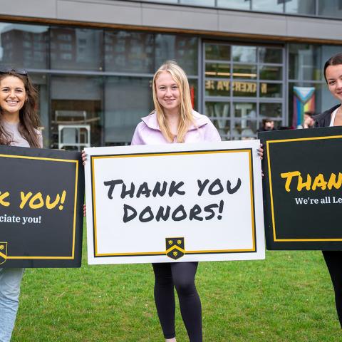 Students holding up thank you signs